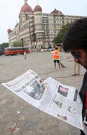 Un periodista indio lee el peridico en las inmediaciones del hotel Taj Mahal de Bombay. (Foto: EFE)