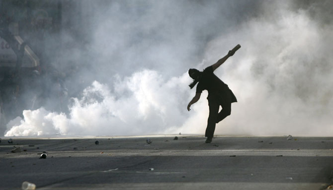 Un manifestante se dispone a lanzar un cóctel molotov a la policía. (Foto: AFP)