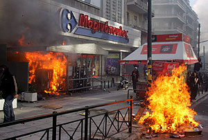 Un supermercado en llamas durante el enfrentamiento entre varios jóvenes y la policía antidisturbios en el centro de Atenas. (Foto: EFE)