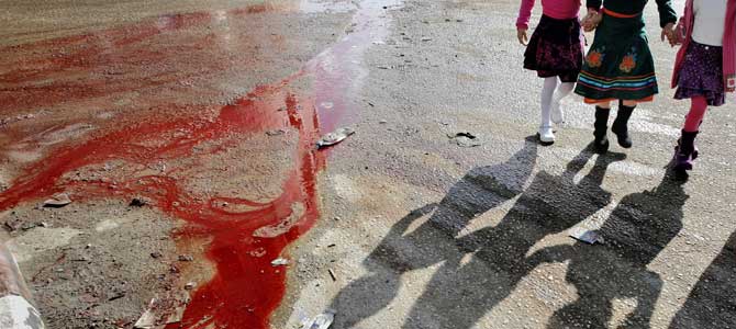Unas nias palestinas pasan delante de un charco de sangre en la fiesta del Sacrificio. (Foto: AP)