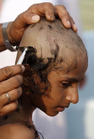 Un joven peregrino mientras le rapan el pelo como seal de purificacin. (Foto: EFE)