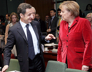 Sarkozy Merkel departiendo en la cumbre de la UE que se celebra en Bruselas. (Foto: EFE)