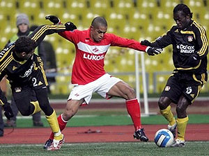 Un jugador del Spartak intenta driblar a dos defensores durante un partido.