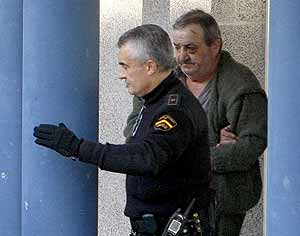 Un polica escolta a Maximino Couto despus de ser detenido por el asesinato de su pareja. (Foto: EFE)