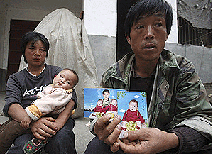 Un hombre chino muestra la foto de sus dos hijas gemelas, una de ellas falleci tras consumir leche de la marca Sanlu (Foto: AP)