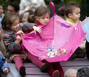 Dos nias recogen en un paraguas los caramelos en Sevilla. (Foto: EFE)