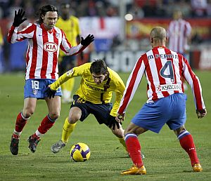 Messi intenta regatear a los atlticos Maniche y Perna. (Foto: EFE)