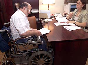 Un hombre en silla de ruedas presenta un escrito en un despacho. (Foto: ngel Casaa)