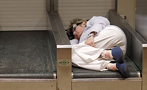Una pasajera duerme en una cinta de un puesto de facturacin. (Foto: Bernardo Daz)
