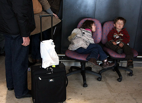 Dos nios duermen en Barajas mientras esperan su vuelo. (Foto: Kika Para)