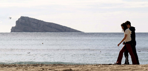 Dos personas disfrutan de un soleado dia en la playa de Levante de la localidad alicantina de Benidorm. (Foto: EFE / Manuel Lorenzo).