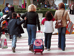 Unas madres recogen a sus hijos a la salida del colegio en Valencia. (Foto: Benito Pajares)
