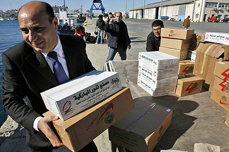 Activistas internacionales cargan cajas con suministros mdicos en el Espritu de la HUmanidad en el puerto de Larnaca. (Foto: AP)