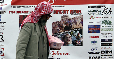 Un hombre ante un cartel que llama al boicot de varias empresas, en Bahrein. (Foto: AP)