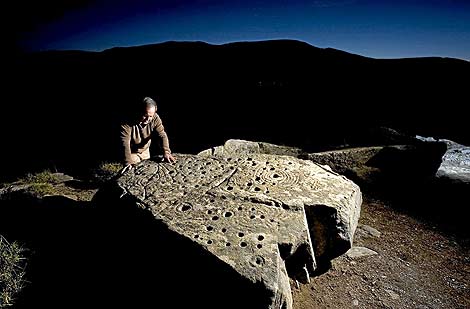 Juan Carlos Campos posa junto a una de las piedras con petroglifos. (Foto: Amando Casado)