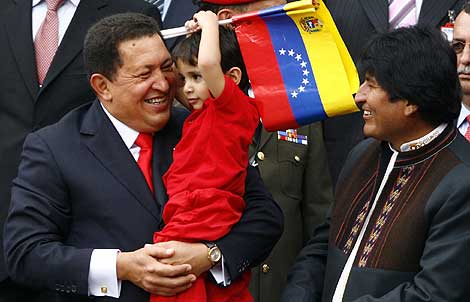 Chávez sostiene a un niño durante uno acto de su décimo aniversario. | Efe