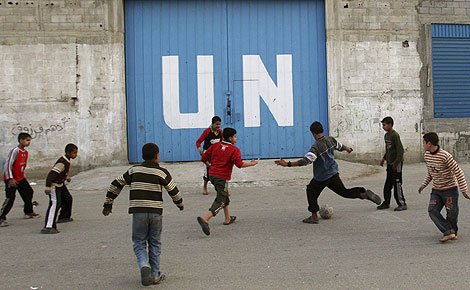 Un grupo de nios juega al ftbol ante un centro de distribucin de alimentos de la ONU en Gaza. | AP