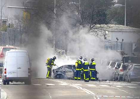 Varios bomberos extinguen las llamas en un coche afectado por la explosión. | Foto: AFP