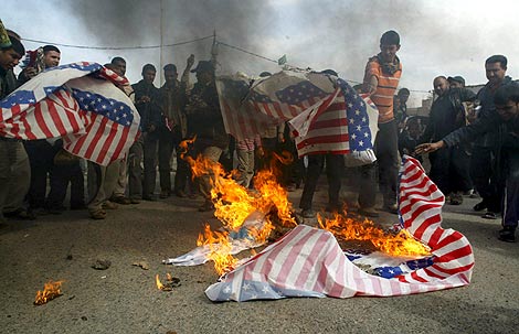 Seguidores del clrigo estadounidense Mutqada al Sadr queman una bandera. | Efe