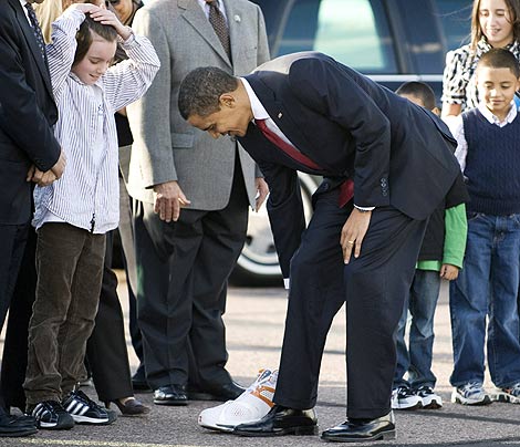 Obama compara su pie con una zapatilla del jugador de la NBA Shaquille O'Neal, en Phoenix. | Reuters