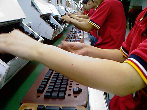 Unos trabajadores insertan unas teclas. (Foto: NLCNet)