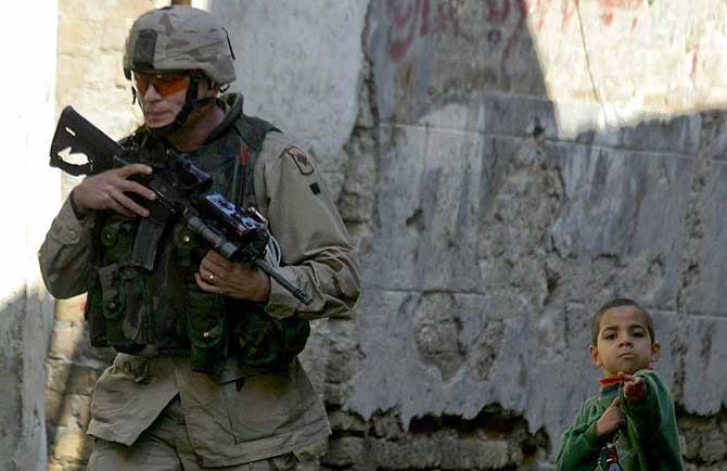 Un soldado estadounidense pasa junto a un nio iraqu. (Foto: EL MUNDO)