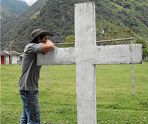 Un vecino de Puerto Brasil se apoya en una cruz de piedra en la aldea. | Jorge Cullar