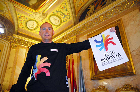 Paco Monedero sostiene la bandera de la capitalidad europea de Segovia. | F. Pealosa