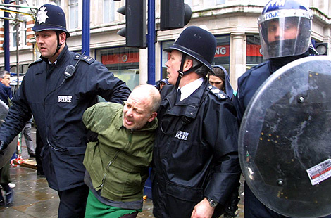 La polica detiene a un manifestante en un protesta en Londres.