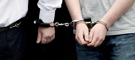 Las manos del primer acusado, esposadas junto a las de un polica. | AP