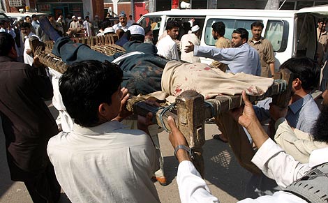 Varios ciudadanos trasladan uno de los cuerpos. | AFP