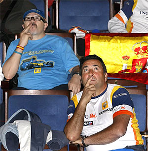 Dos seguidores de Alonso siguen la carrera en el auditorio Prncipe Felipe de Oviedo. (Foto: EFE)