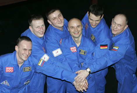 Los seis voluntarios unen sus manos antes de encerrarse en la cpsula en Mosc. | Reuters