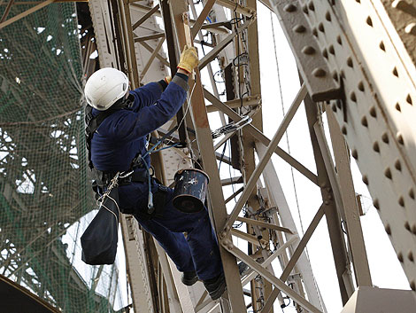 Un pintor trabaja en la Torre Eiffel. | Reuters
