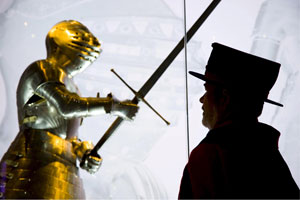 Un guardin de la Torre de Londres observa una armadura del rey Enrique VIII durante una exhibicin. | Efe