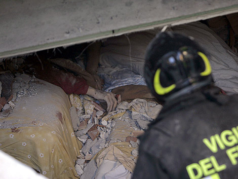 Un bombero intentan rescatar el cuerpo de una persona. | AP