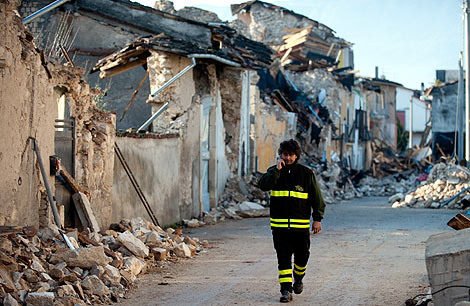 Un bombero camina por las calles de L'Aquila. | AFP