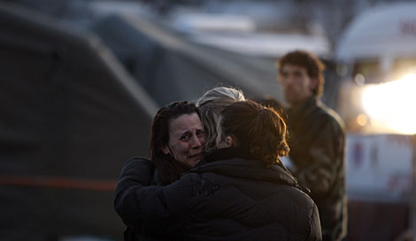 Tres mujeres se abrazan en un campo de refugiados de L'Aquila tras el nuevo temblor. | AP