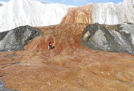 Un investigador posa sobre la superficie helada de 'Las cataratas de sangre'. (Foto: 'Science')