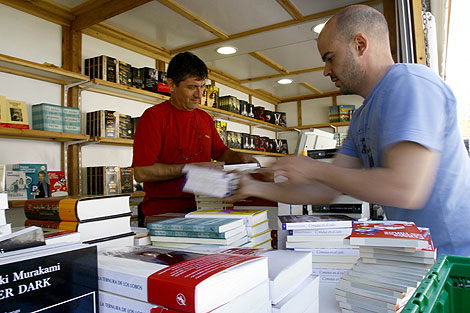 Dos libreros ultiman el montaje de su expositor en Valencia. | V.B.