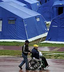 Un hombre empuja a otro en silla de ruedas. | AFP