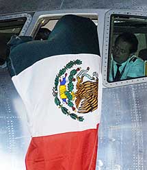 El piloto cuelga una bandera mexicana de una ventana del avin. | AFP