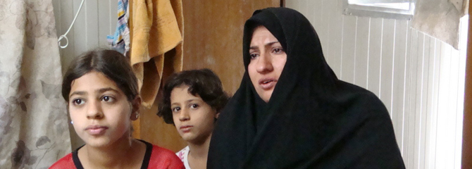 La viuda Salwa Jabus, junto a dos de sus hijas, en el campamento de Al Shaab, en Bagdad. | M. G. P.