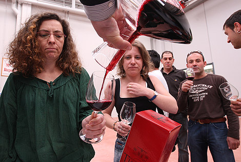 Un expositor sirve con un decantador el vino a una de las visitantes que acudieron a la jornada inaugural de Riberexpo. | J. M. Lostau