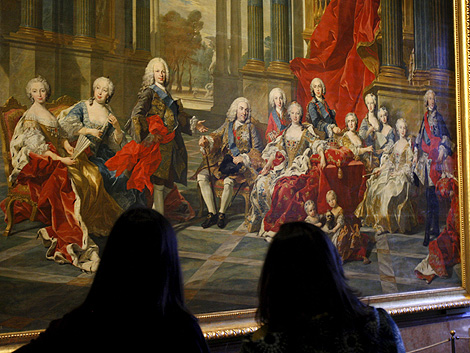Dos visitantes del Prado, ante el cuadro 'La Familia de Felipe V', de Louis Michel van Loo, que se expone estos das en la capital. | Efe