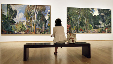 Una mujer observa los cuadros titulados El Mas Blau, del pintor cataln Joaquim Mir. | Efe