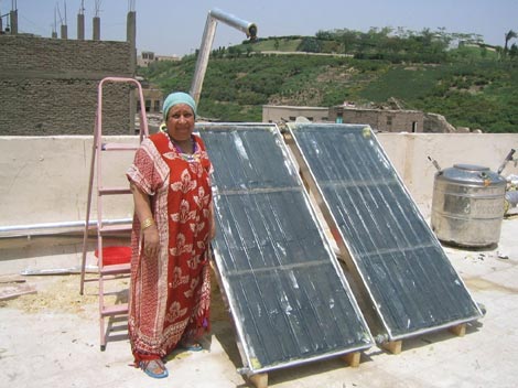 Una mujer egipcia ensea su calentador solar en la azotea de su casa. /Thomas Culhane