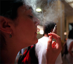 Una mujer, fumando en el aeropuerto de Barajas. (Foto: Chema Tejada)