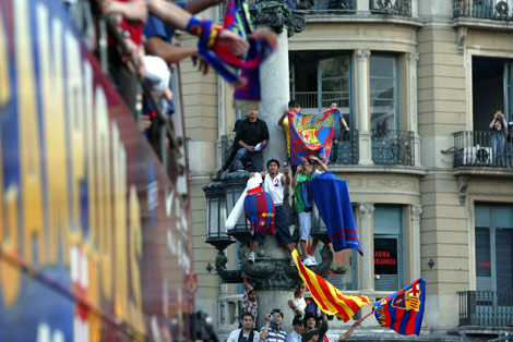 Aficionados vitorean a los jugadores a su paso por plaza Catalunya . | Domnec Umbert
