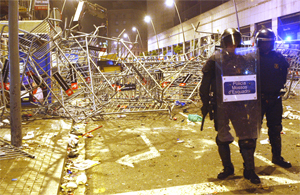 Mossos ante el amasijo de vallas que los alborotadores utilizaron de barricada. (Foto: Quique Garca)